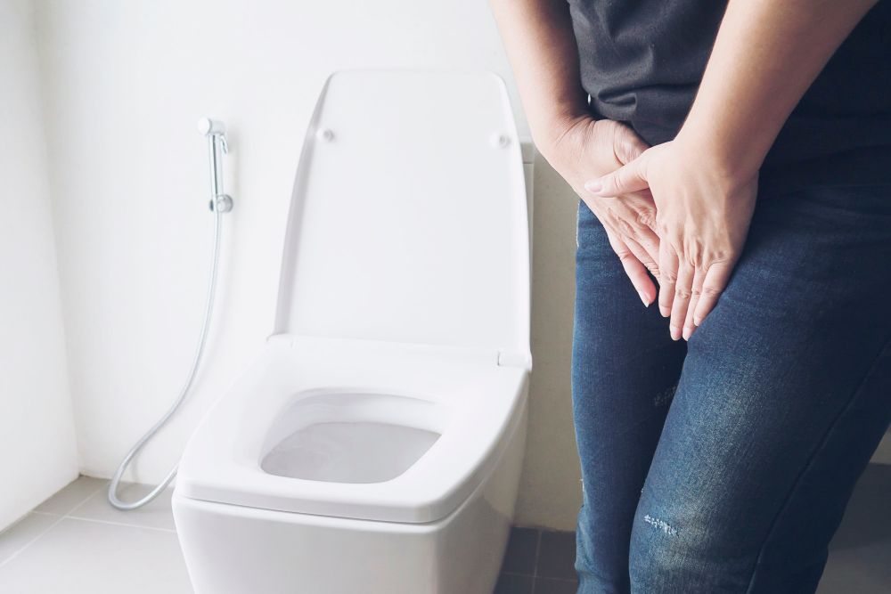 woman holding hand near toilet bowl health problem concept